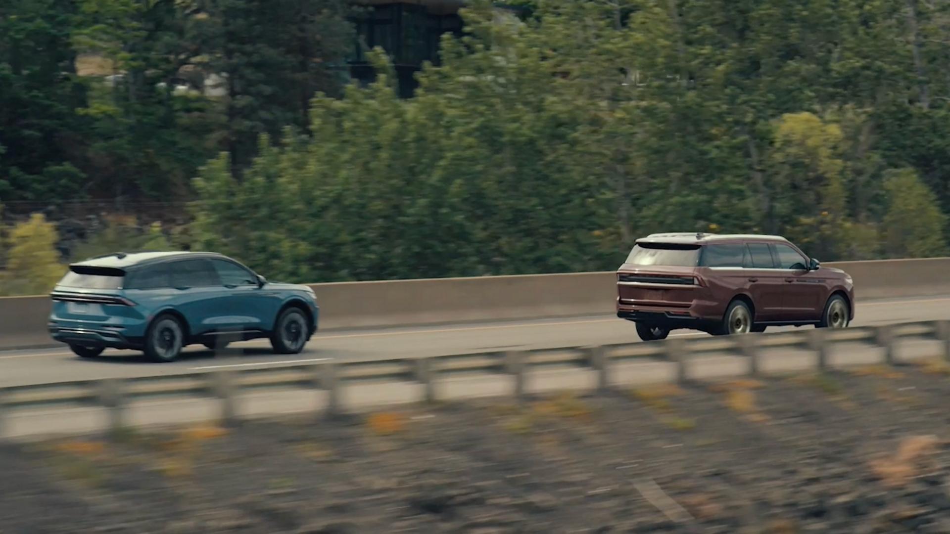 The 2027 Lincoln Navigator® SUV driving on a highway alongside a Lincoln Aviator SUV