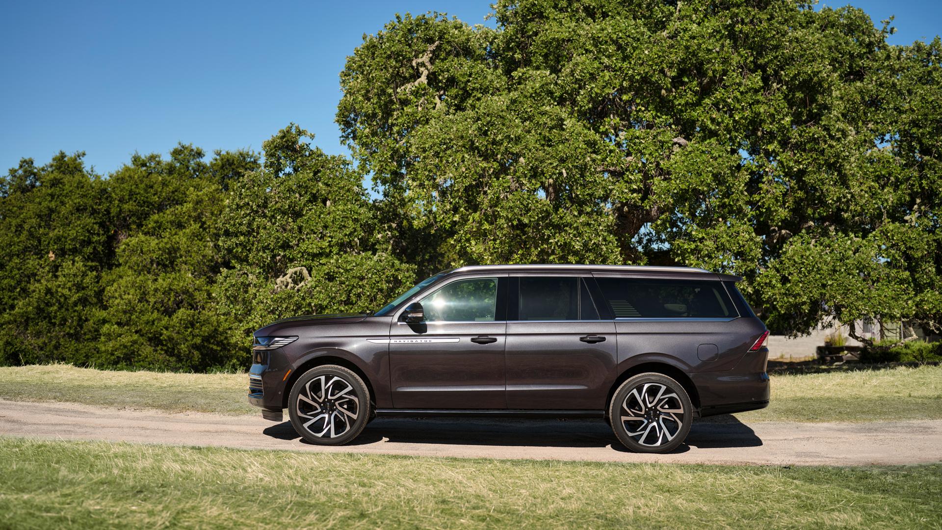 A 2026 Lincoln Navigator® with the available long wheelbase is parked on a tree-lined road