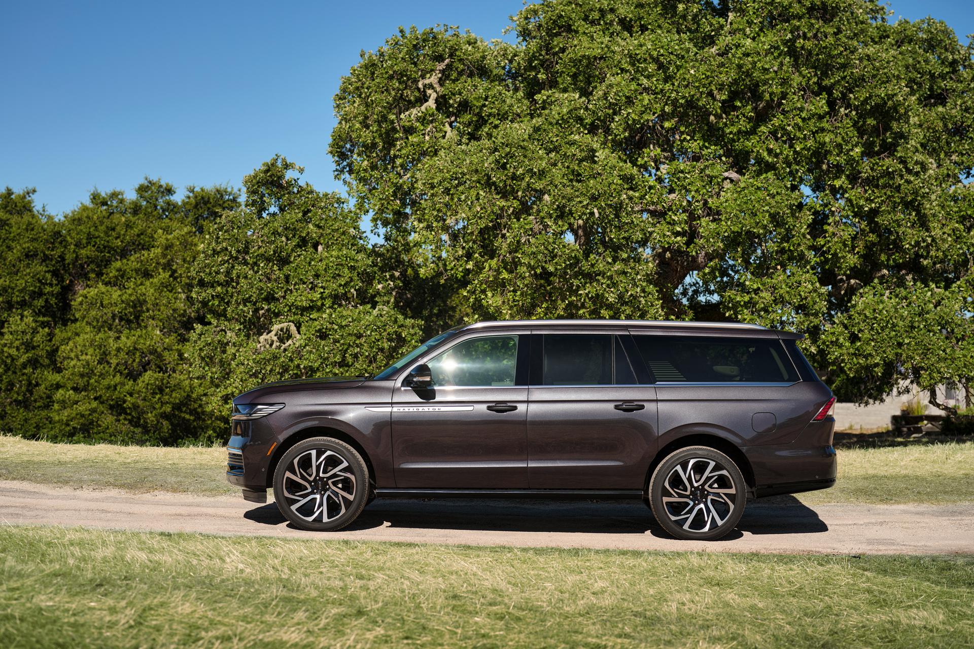 A 2026 Lincoln Navigator® SUV with the long wheelbase is parked on a tree-lined road