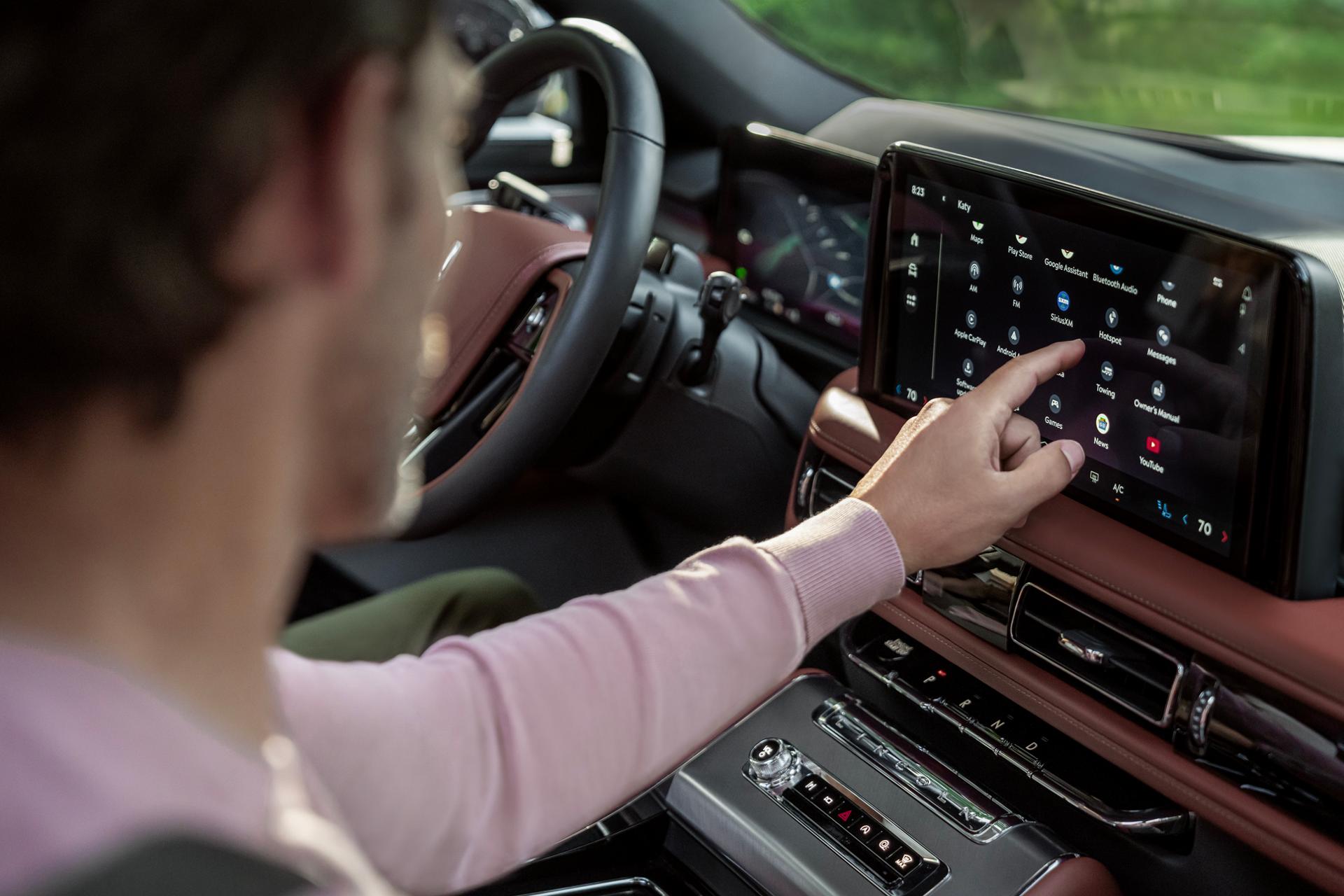 The front passenger of a 2027 Lincoln Aviator® SUV interacts with the centre display
