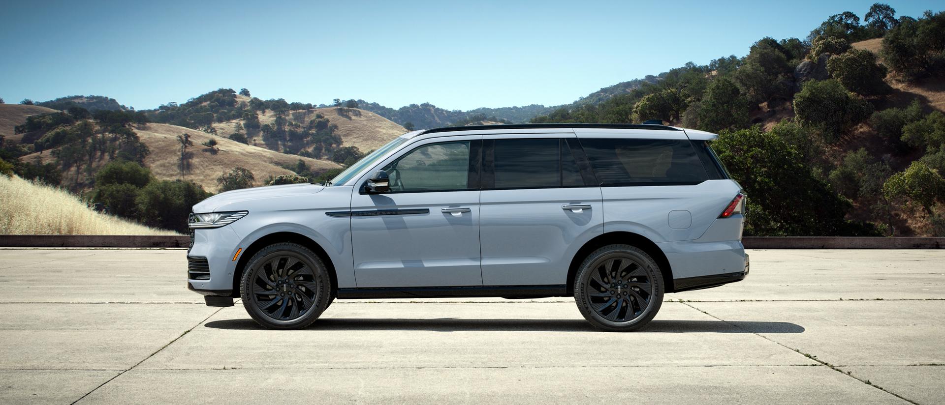A 2027 Lincoln Navigator® SUV with the available Atmospheric Black Label™ theme is parked in front of a modern home