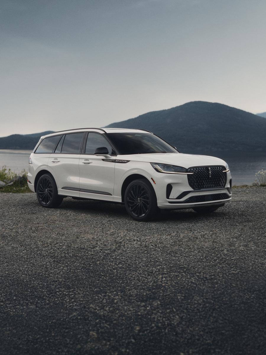 Lincoln Aviator luxury SUV parked beside a scenic mountain lake.