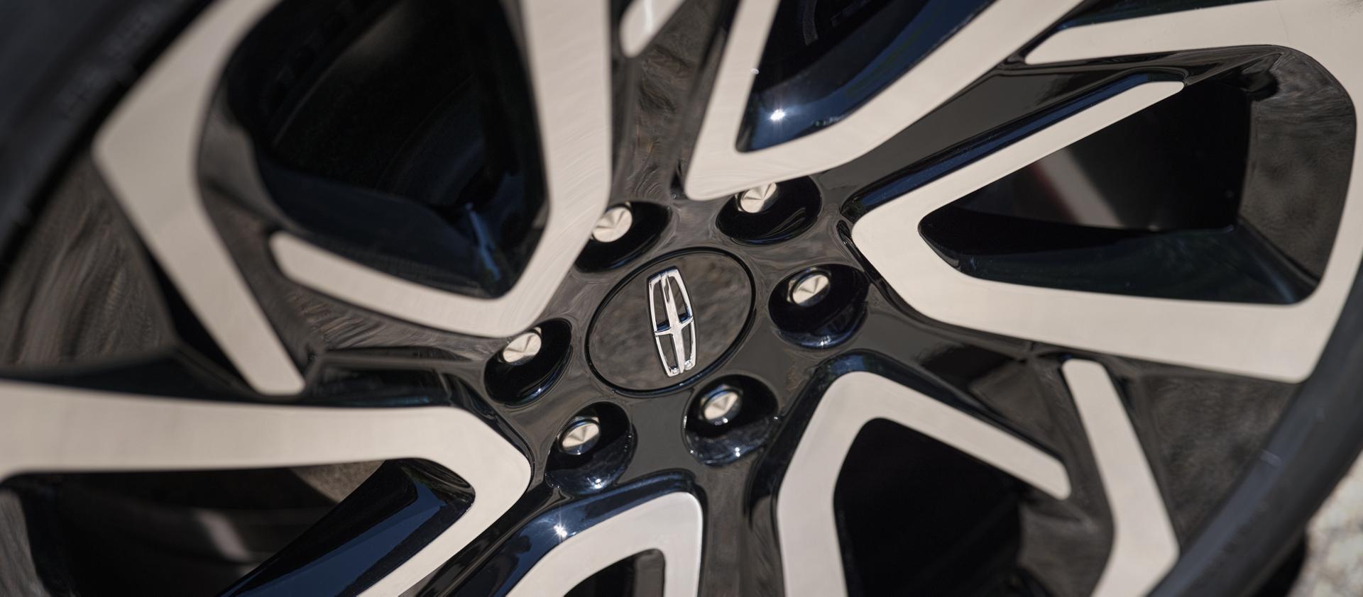 24" high-gloss Ebony Black-painted wheel with bright-machined finish on a 2027 Lincoln Navigator® Black Label™ model