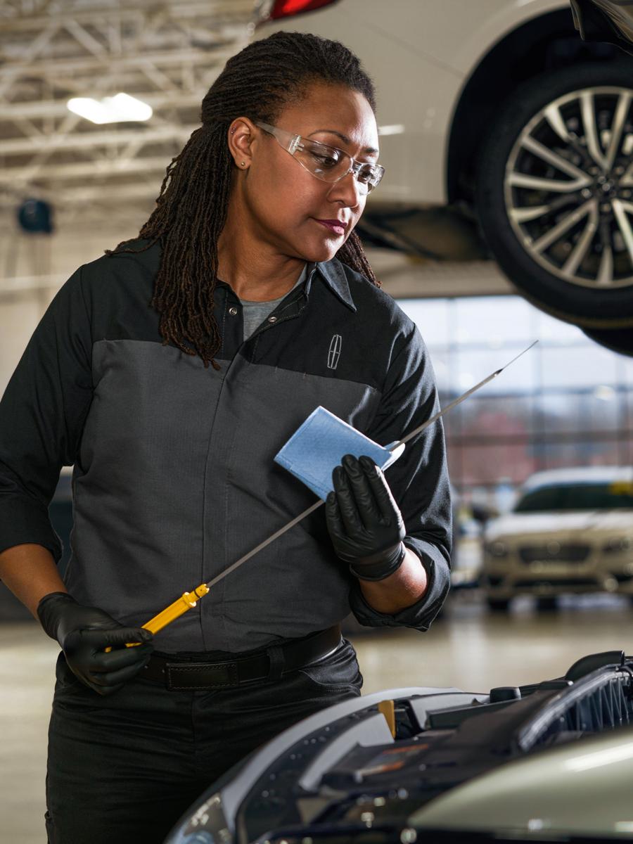 Lincoln technician performing vehicle maintenance.
