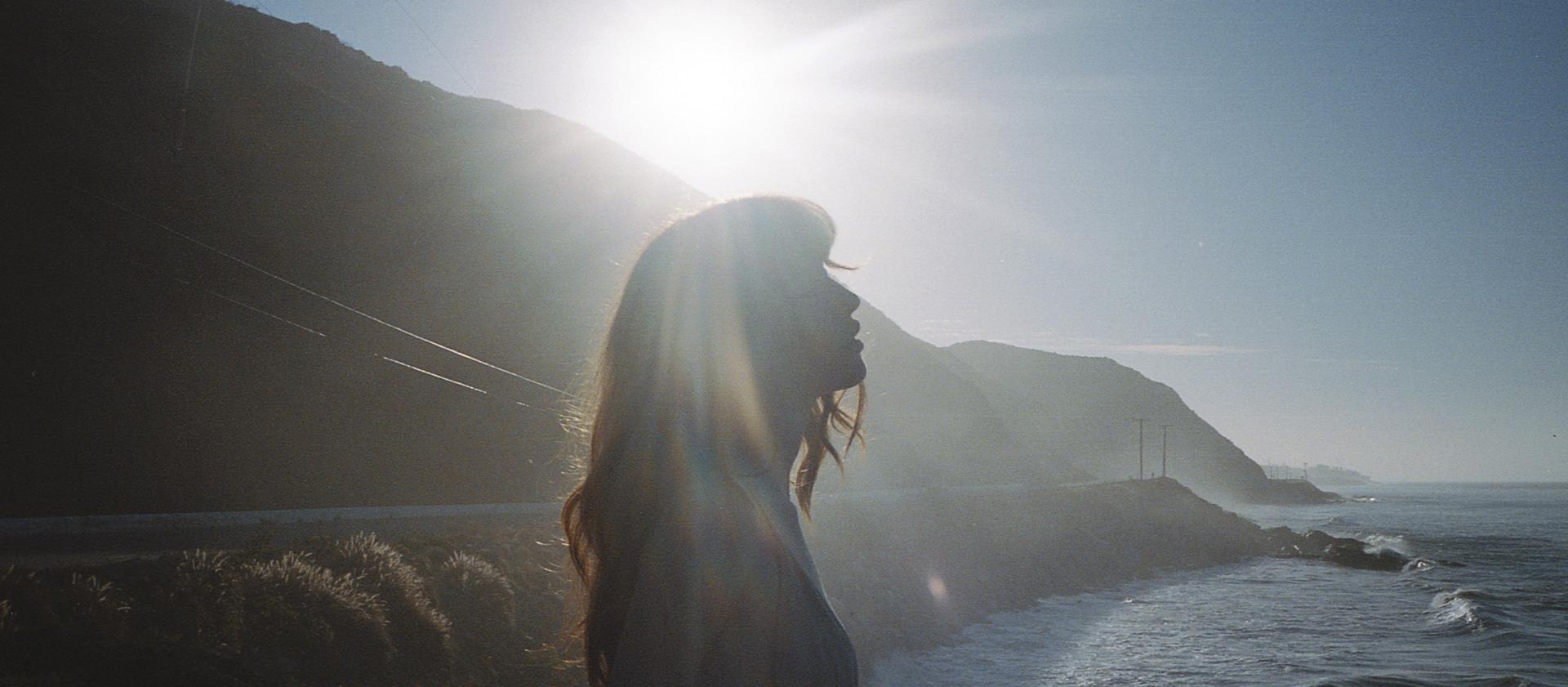 A woman enjoys a moment on a seaside overlook