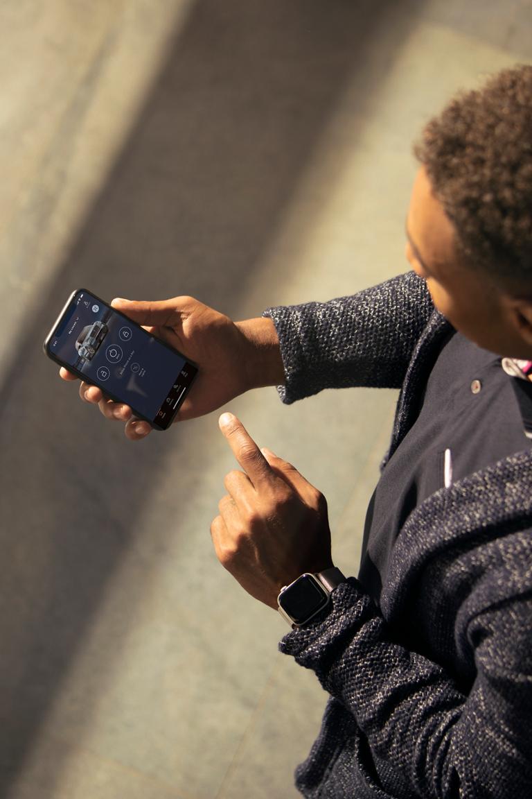 A man views the Lincoln App on his smartphone, pointing to the screen