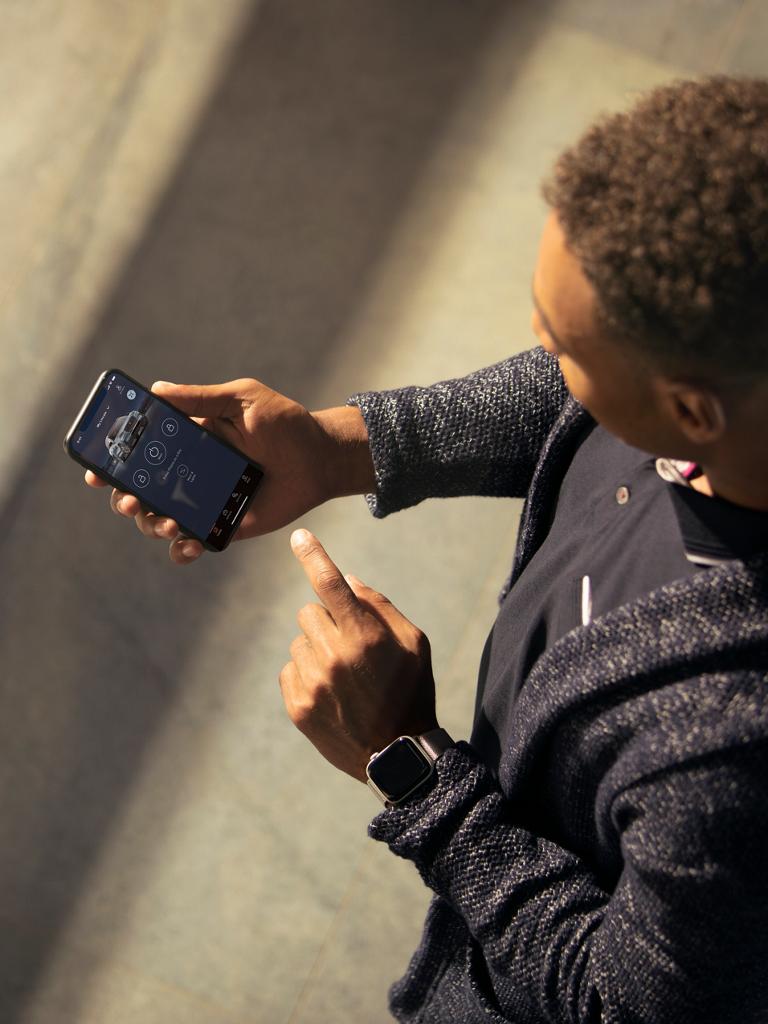 A man views the Lincoln App on his smartphone, pointing to the screen