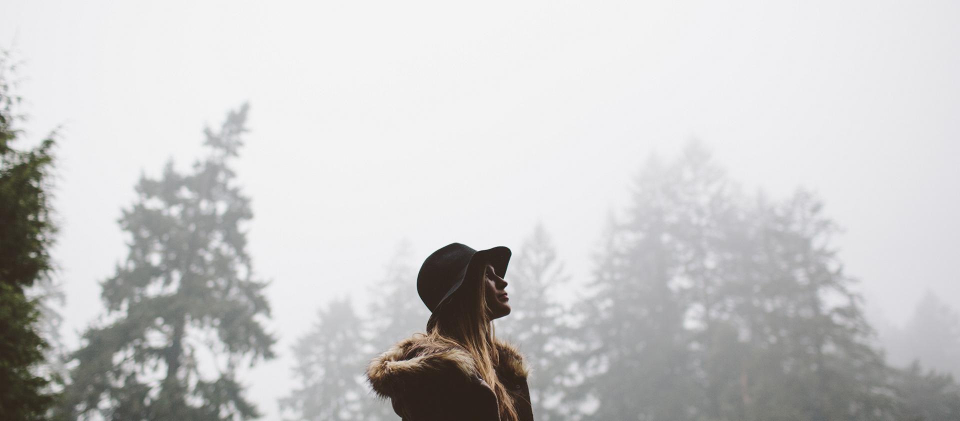 A woman walks through the forest following the conclusion of a rain storm