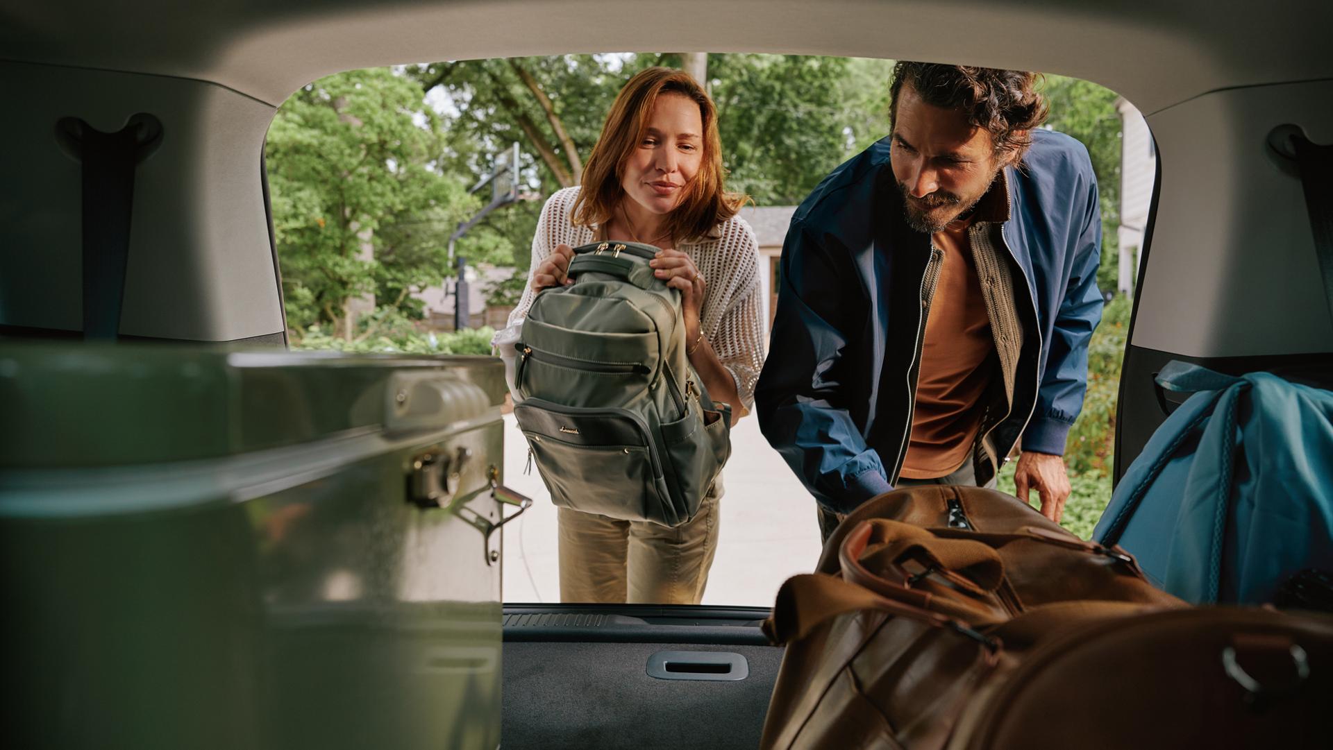 A couple load their 2027 Lincoln Aviator with the Open On Approach liftgate feature