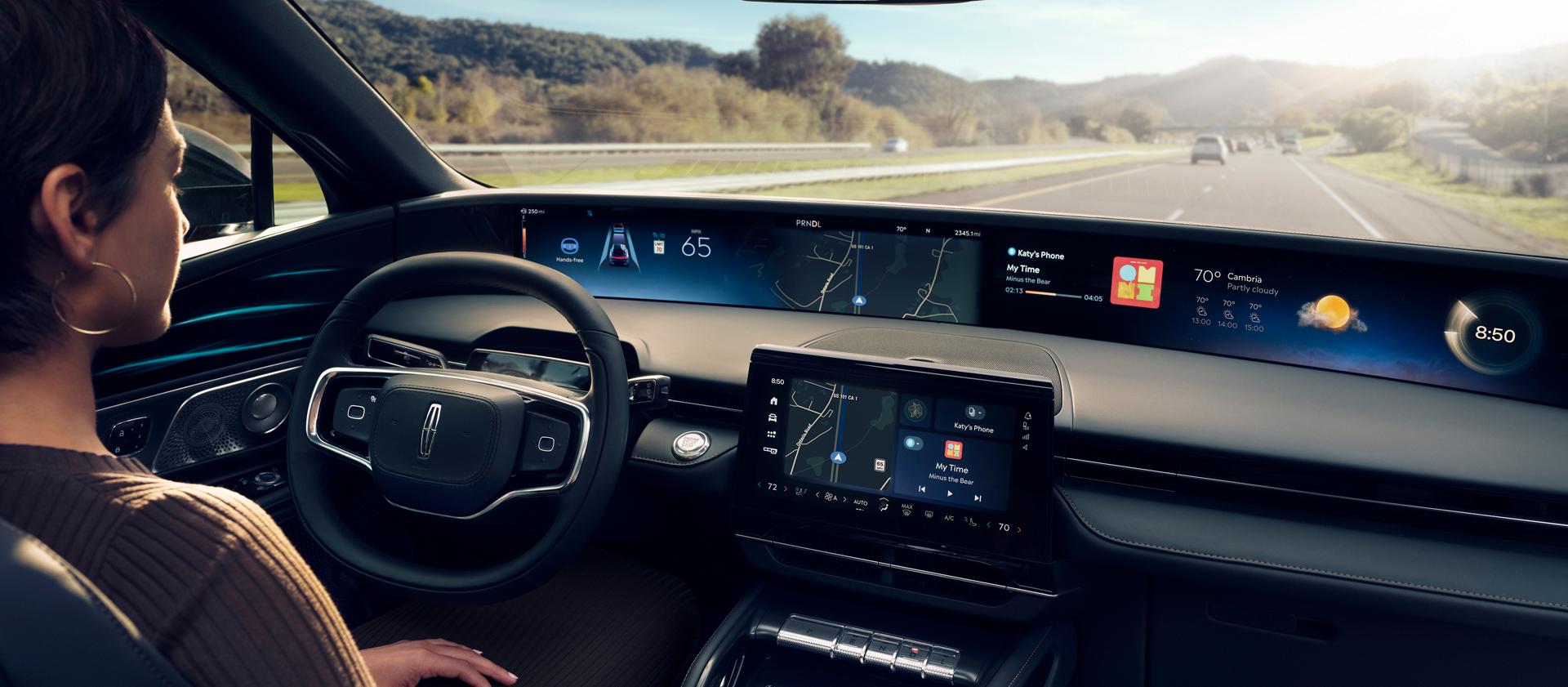 A woman is shown driving Lincoln Nautilus SUV hands-free using Lincoln BlueCruise on a highway.