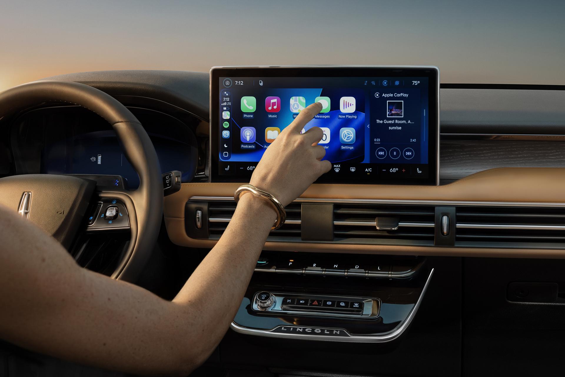 The driver interacts with the center display of a 2027 Lincoln Corsair® Hybrid