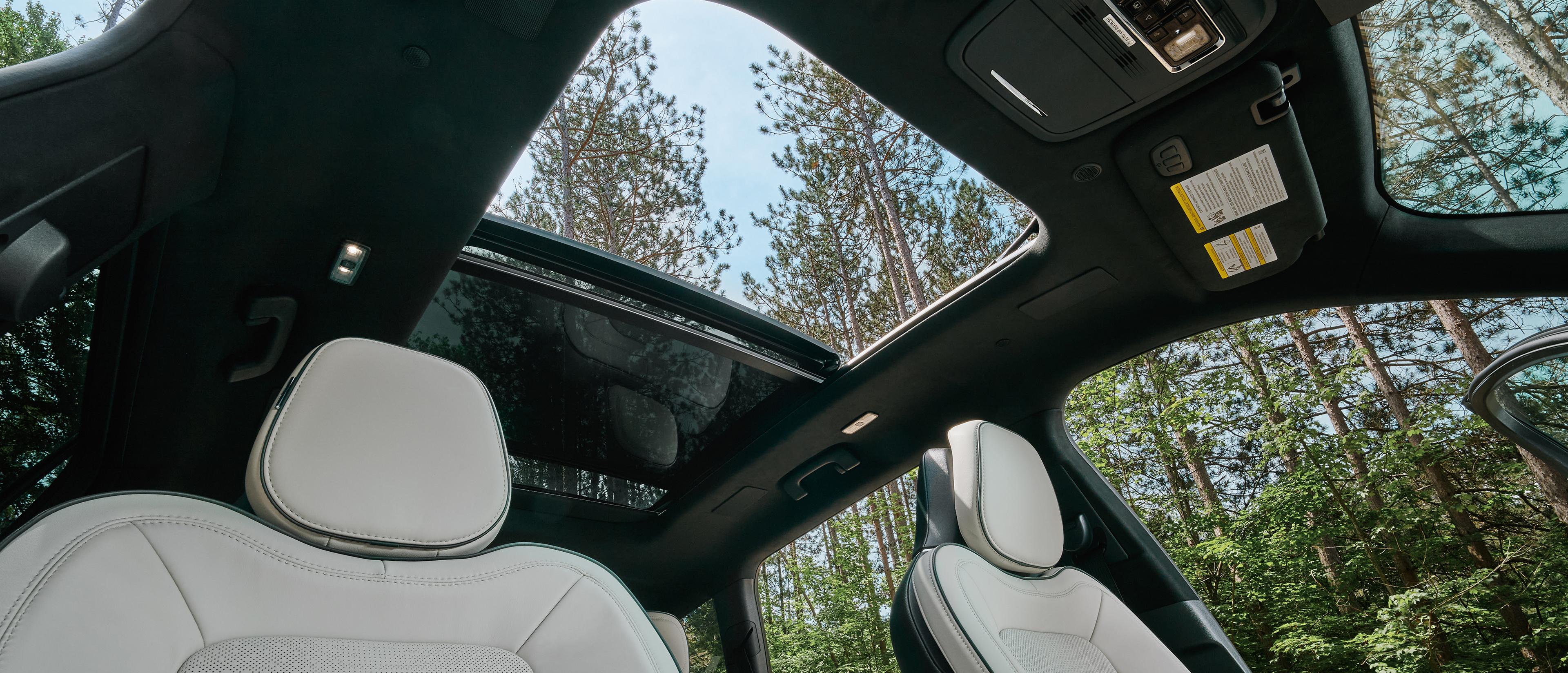 An interior view of a 2027 Lincoln Aviator looking up through the panoramic Vista Roof®