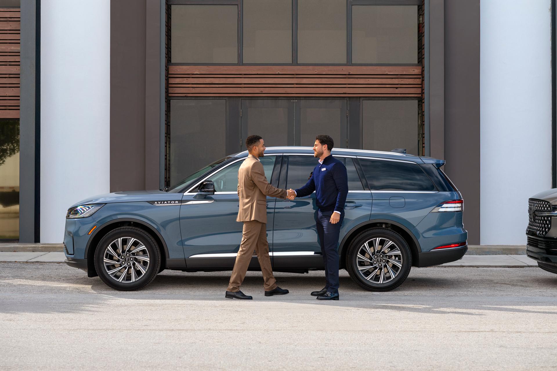 A Lincoln representative interacts with a client inside a Lincoln SUV