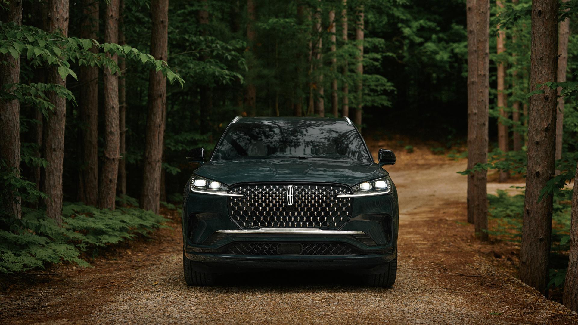 A 2027 Lincoln Aviator® is being driven on a remote forest roadway