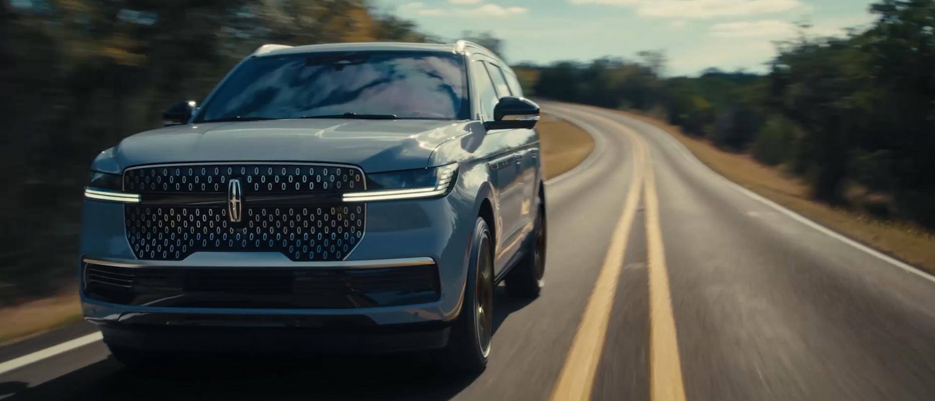 A 2027 Lincoln Navigator SUV is travelling on a scenic highway