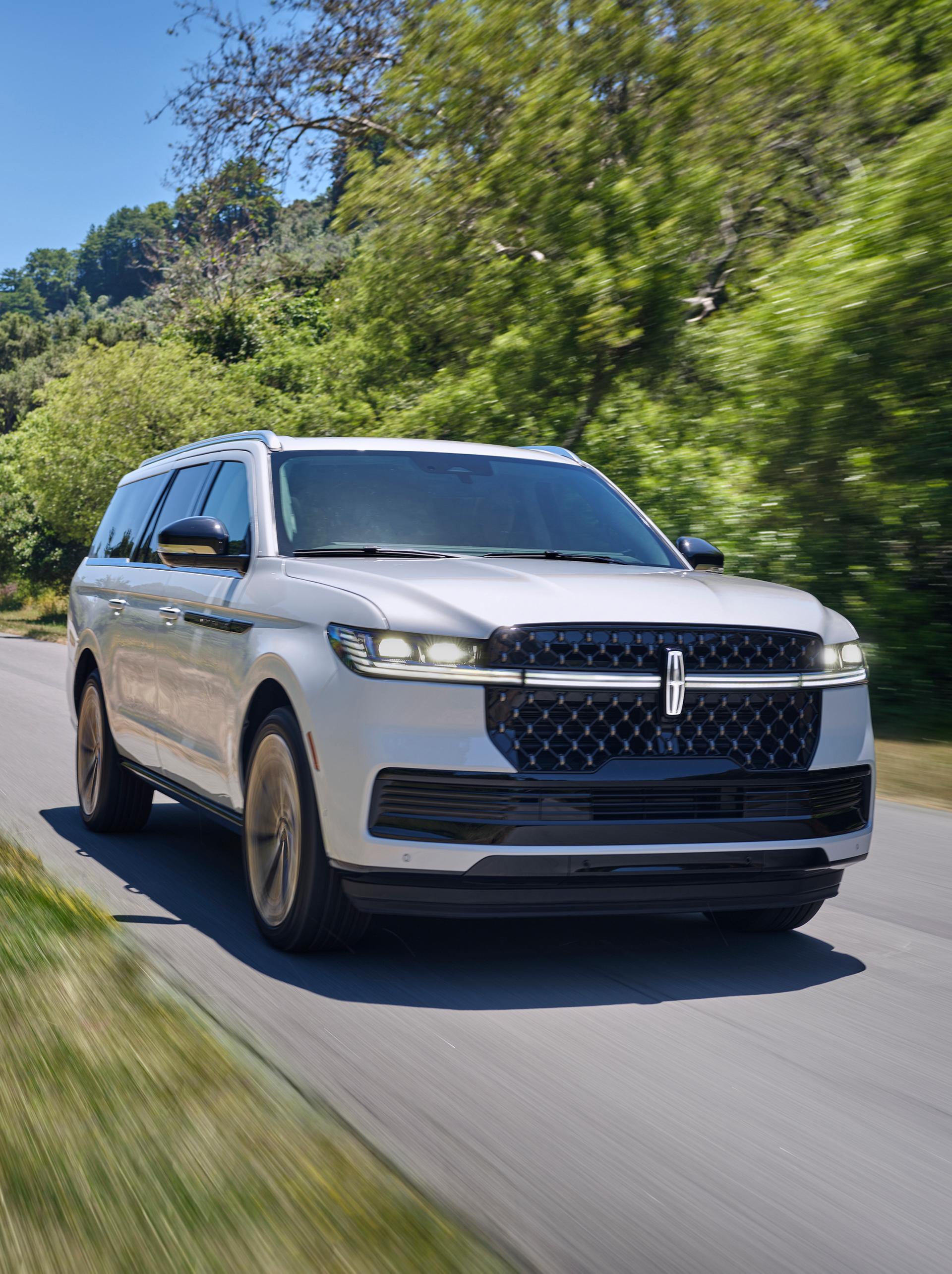 A 2026 Lincoln Navigator® SUV is being driven on a country road
