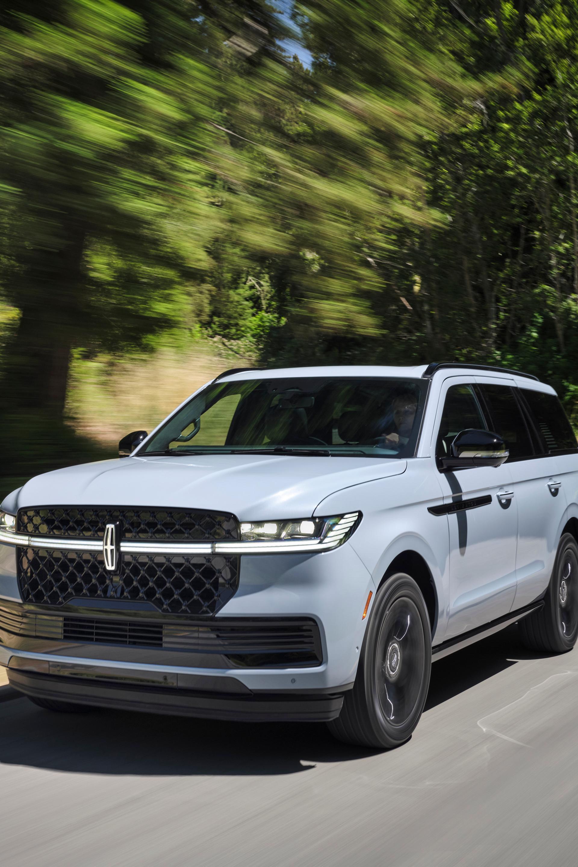A 2026 Lincoln Navigator® SUV is being driven on a country road