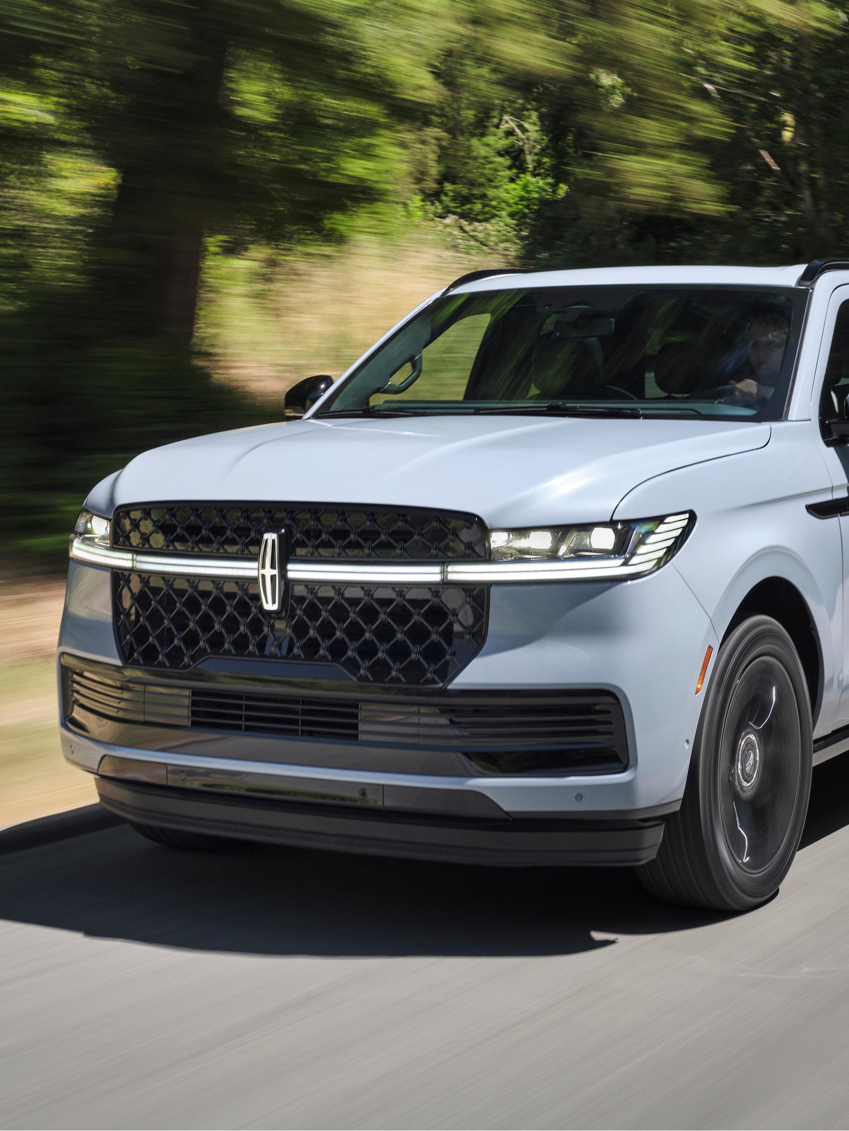 A 2026 Lincoln Navigator® SUV is being driven on a country road