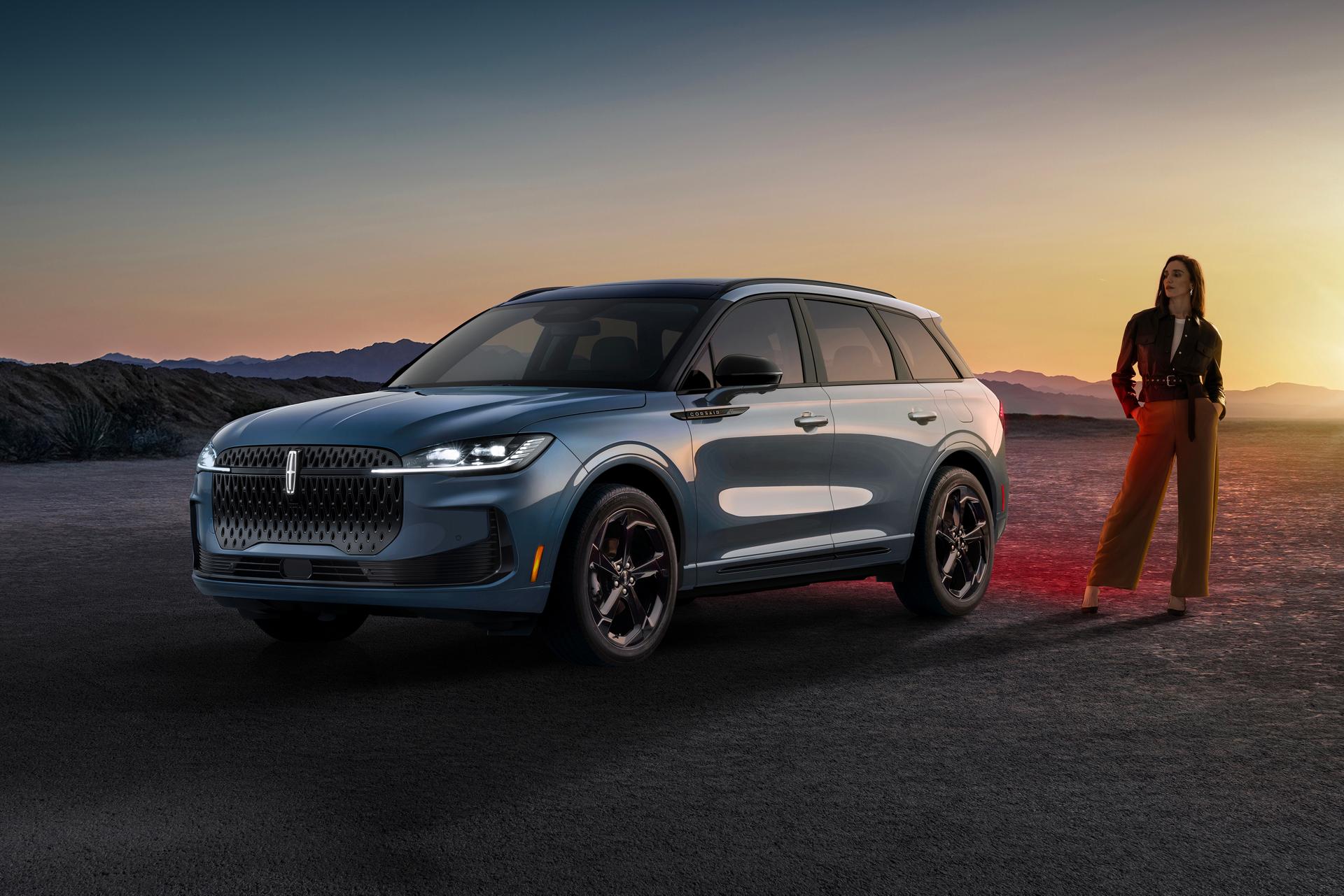 A stylishly dressed woman standing next to a 2027 Lincoln Corsair® Hybrid parked in a dramatic desert landscape.
