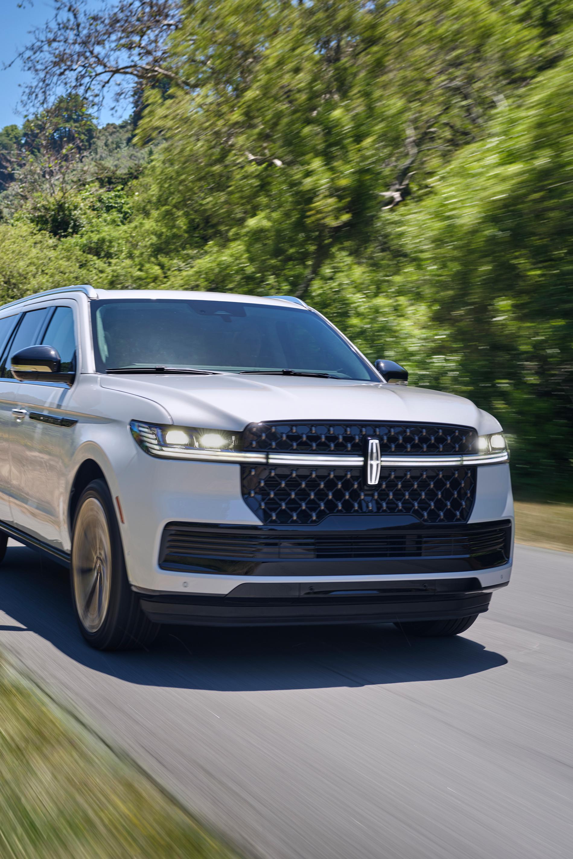 A 2026 Lincoln Navigator® SUV is being driven on a country road