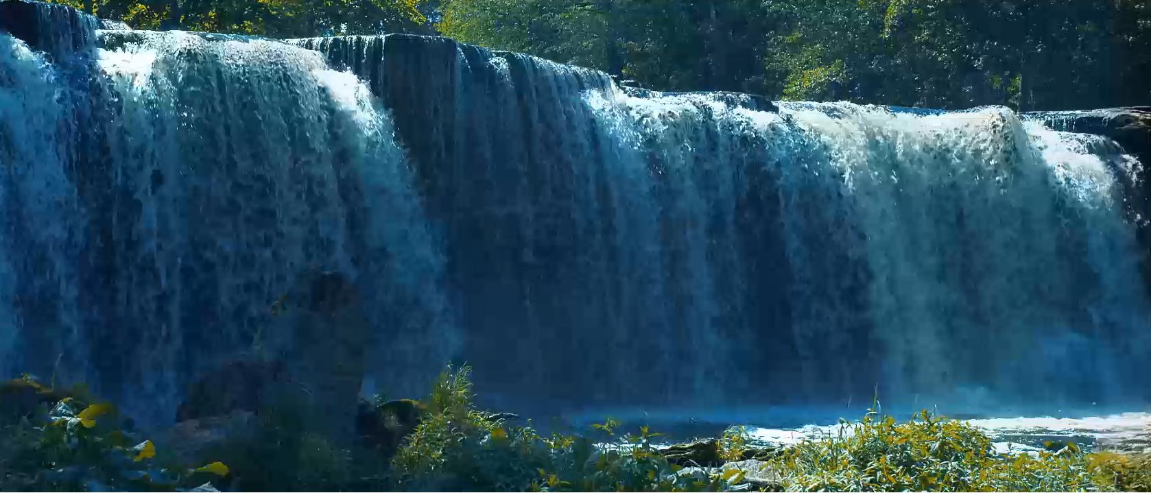 Video thumbnail of the expanded Waterfalls theme showing wide cascading waterfall flowing over a rocky cliff into greenery below.
