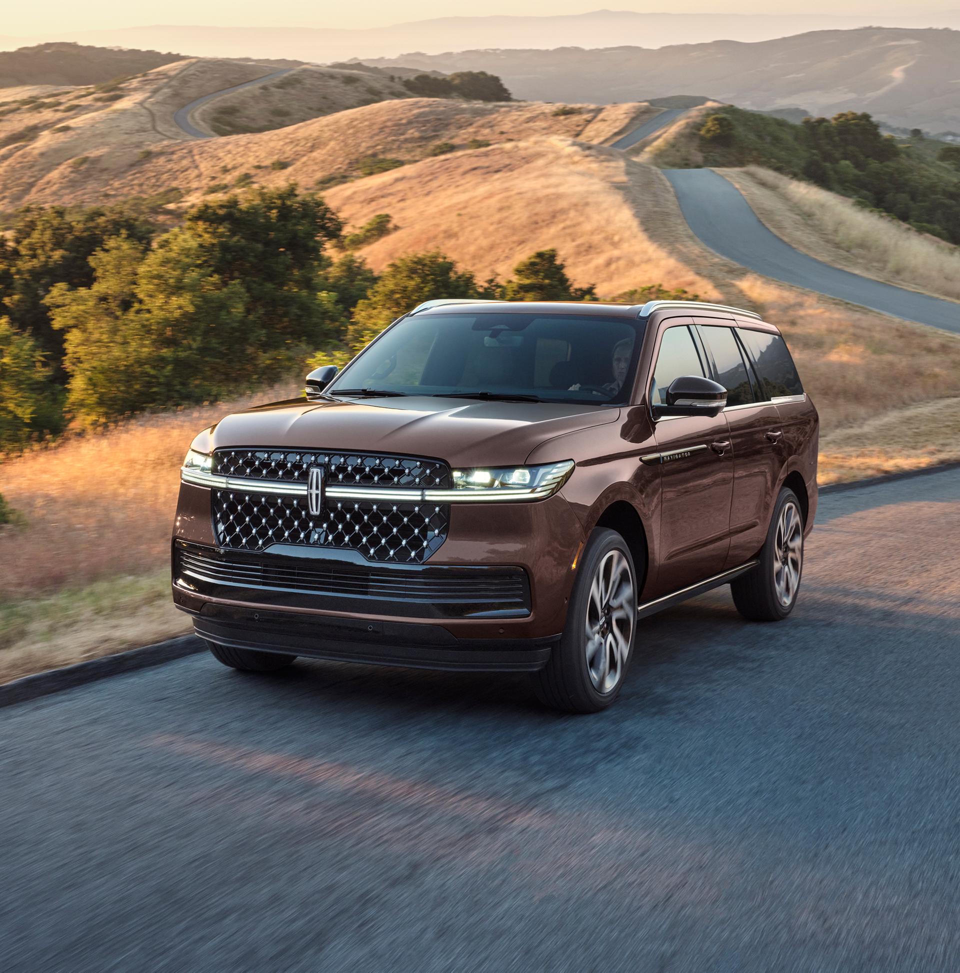 A 2027 Lincoln Navigator® Black Label™ SUV is being driven on a country road