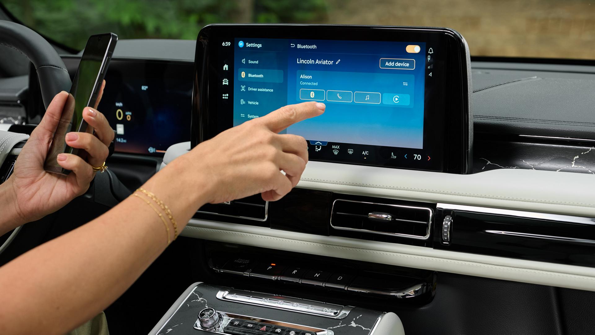 A 2027 Lincoln Aviator owner setting up Wi-Fi® hotspot using the digital display and their phone