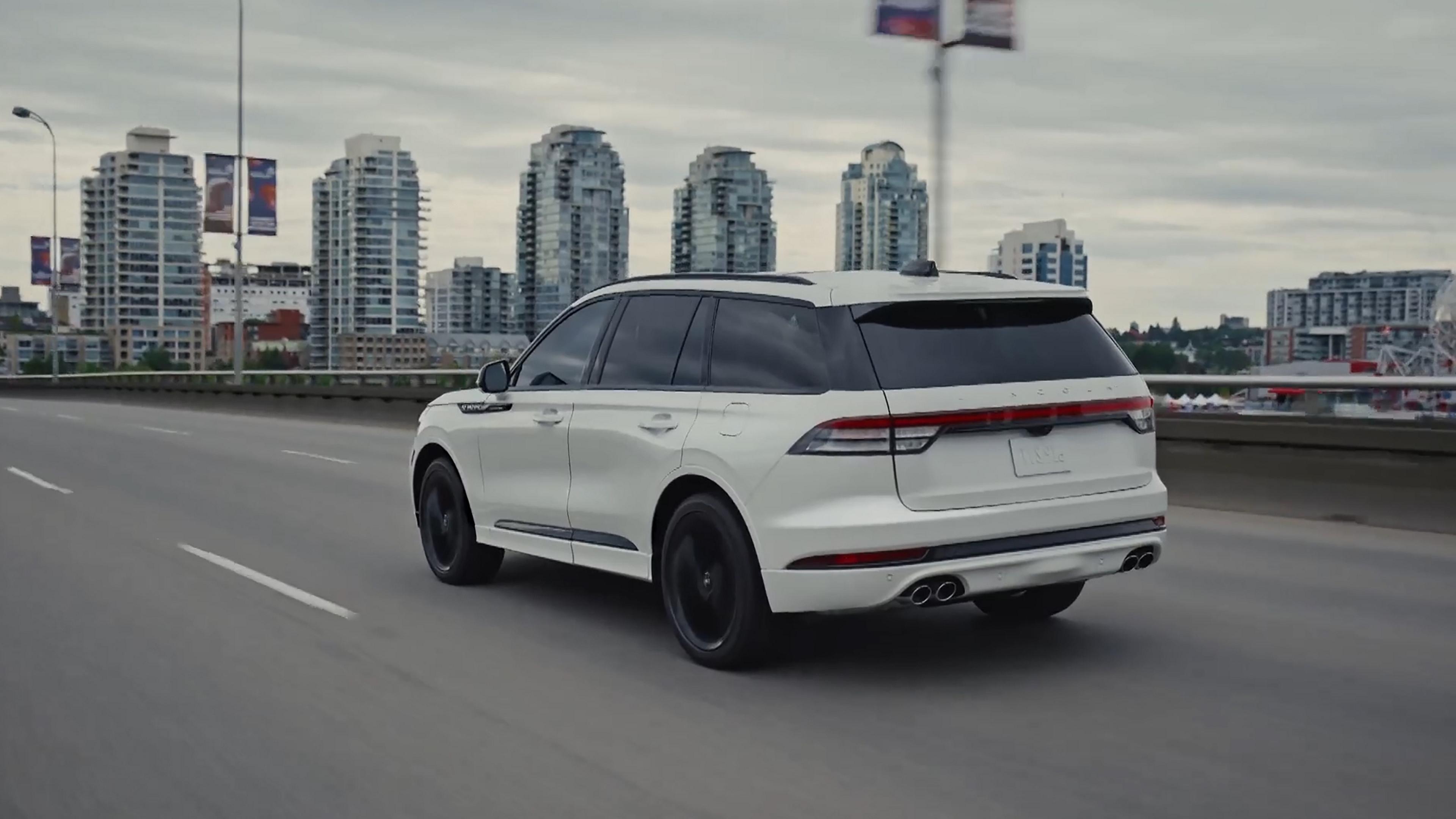 A 2027 Lincoln Aviator SUV is being driven in an urban setting