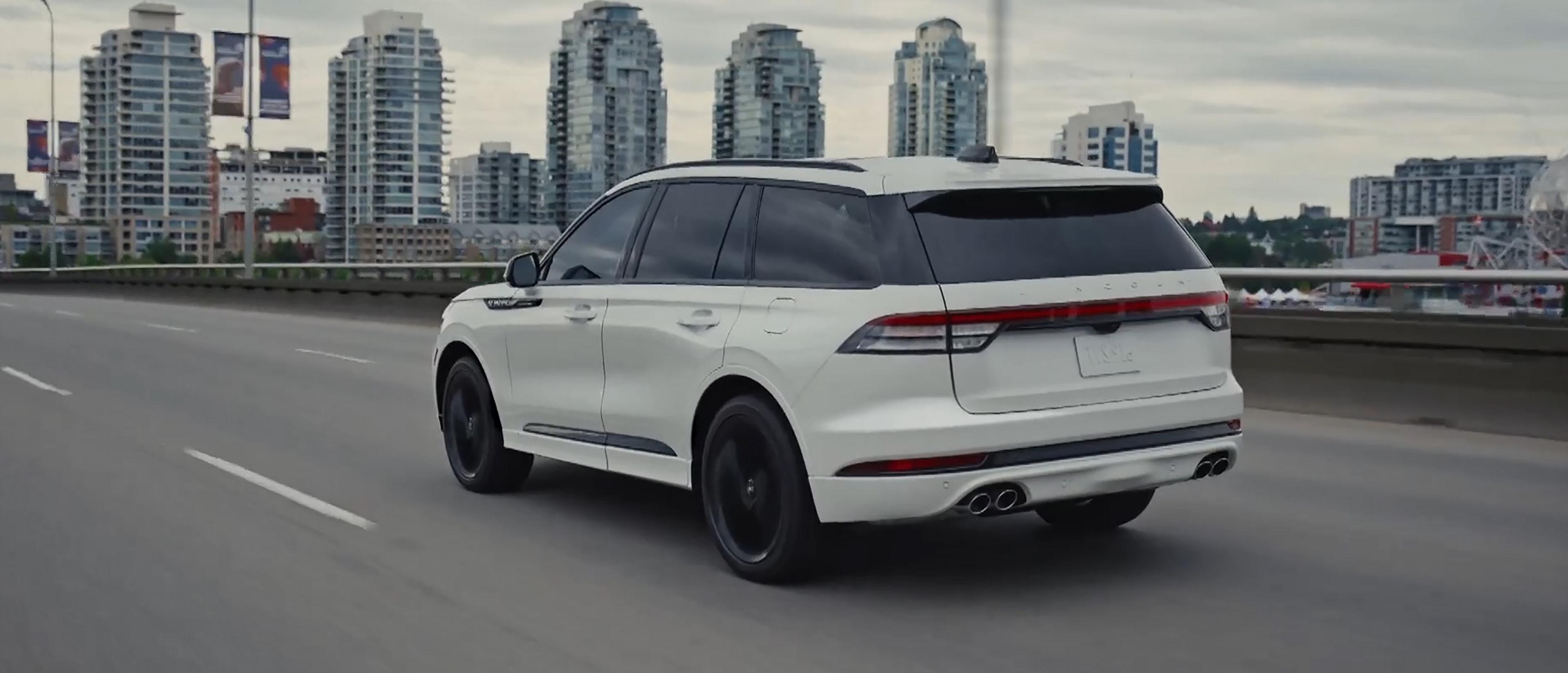 A 2027 Lincoln Aviator is being driven in an urban setting