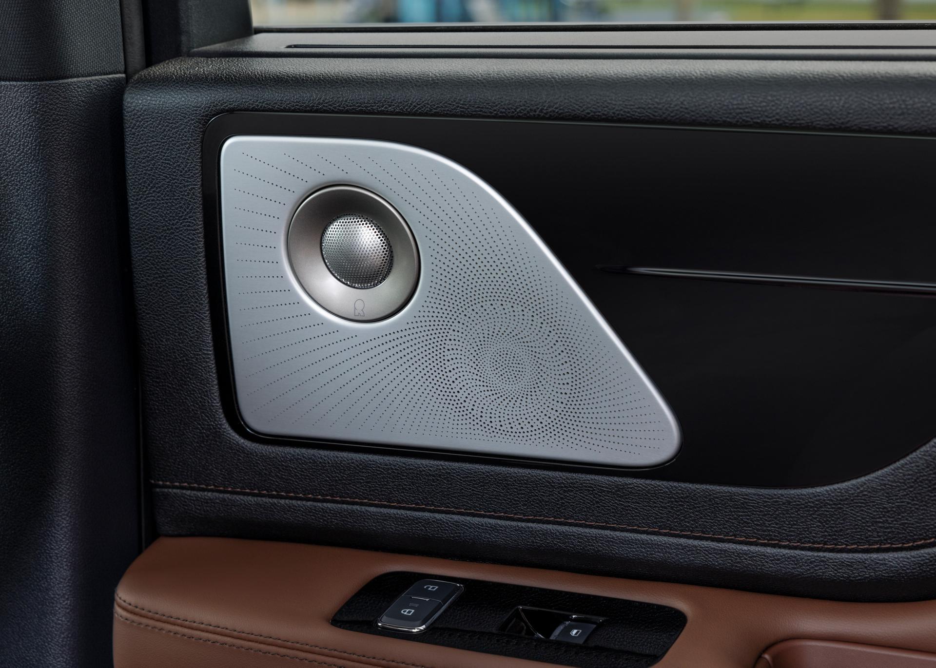 A Revel® speaker is shown on the interior door pane of a 2026 Lincoln Aviator® SUV