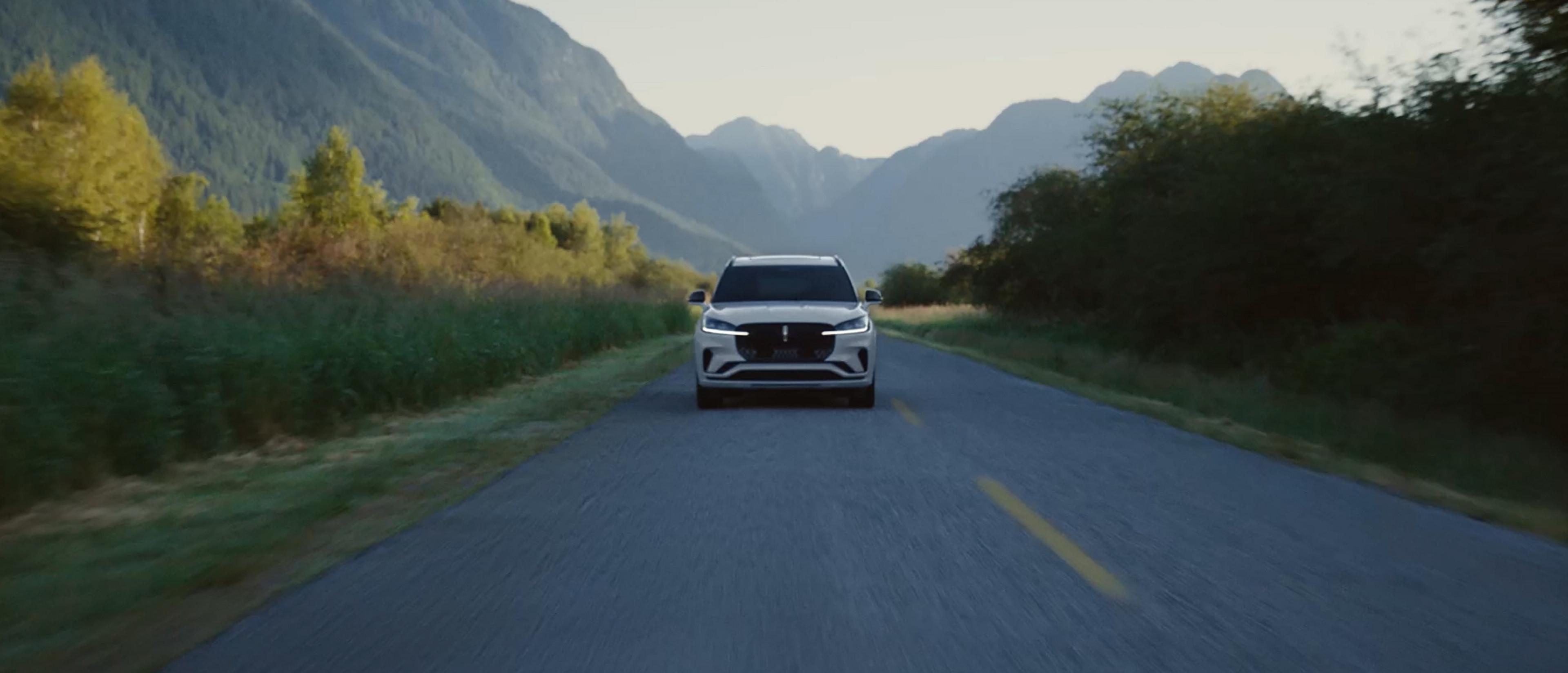 A 2027 Lincoln Aviator is being driven on a country road
