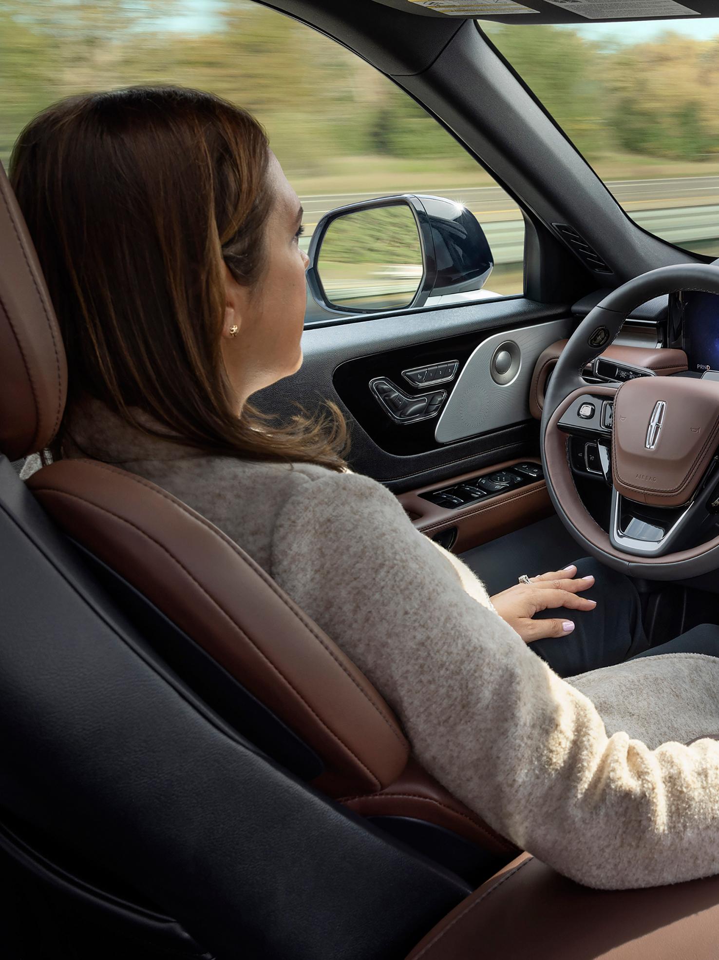 A woman operates the 2026 Lincoln Aviator® hands-free with her eyes on the road using Lincoln BlueCruise