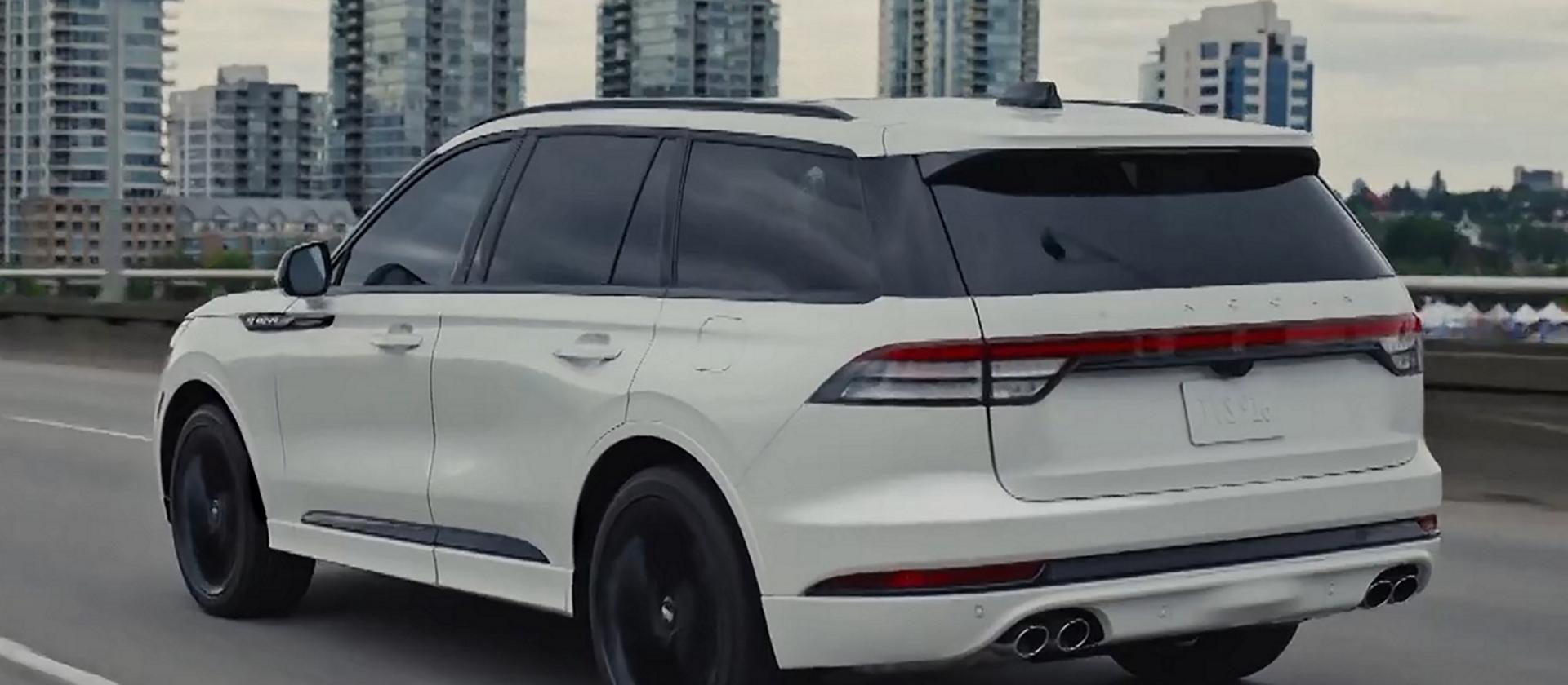 A 2026 Lincoln Aviator is being driven on a highway near a city