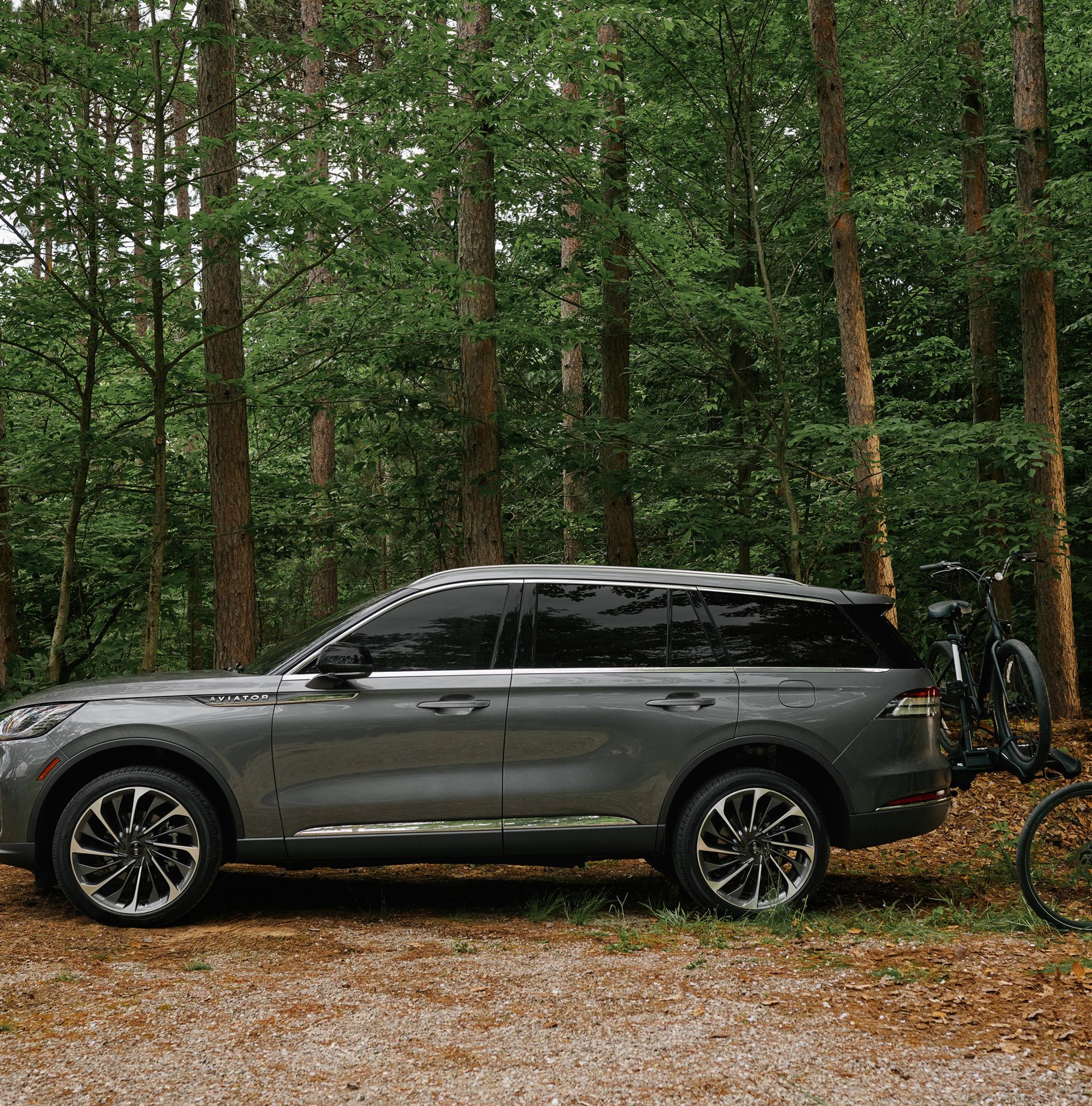 A father and son load bicycles onto a bike rack attached to a 2027 Lincoln Aviator®