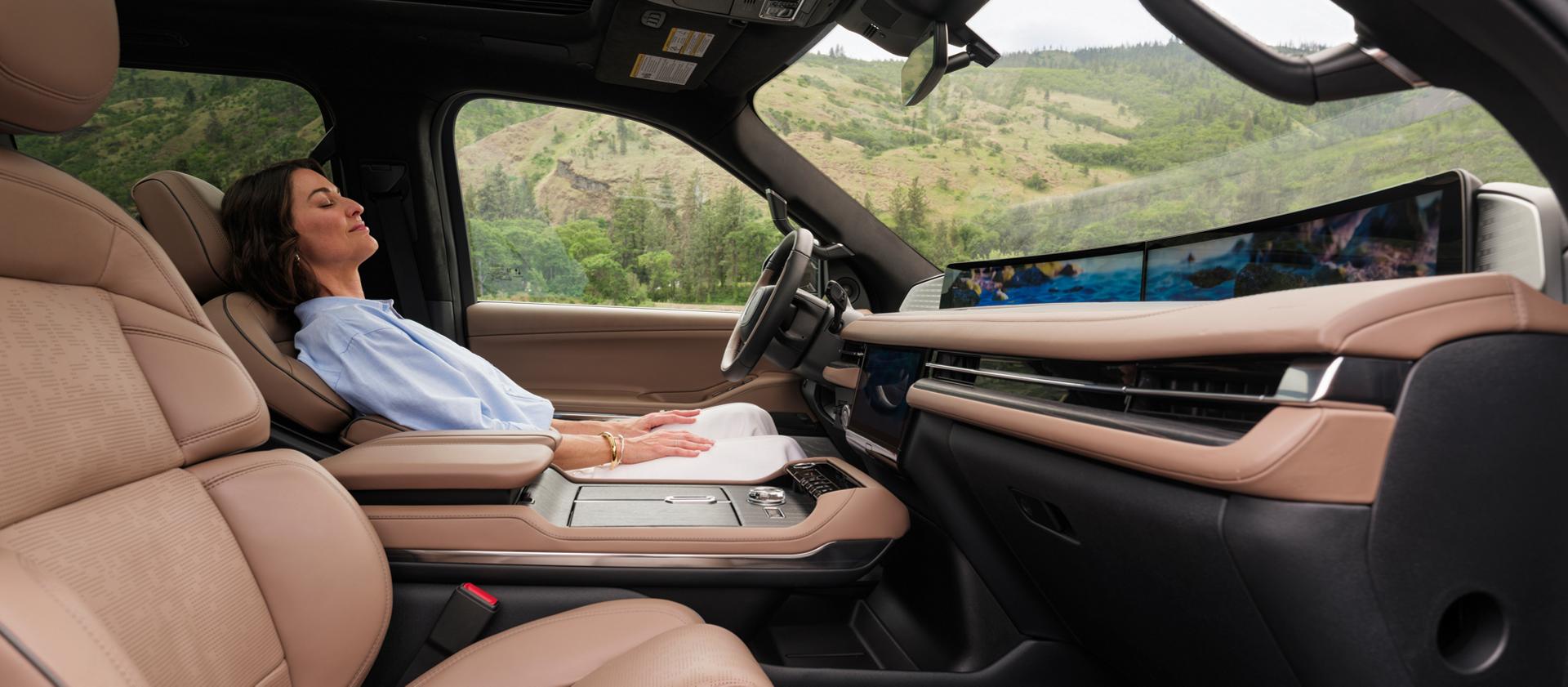 A woman reclines in a 2026 Lincoln Black Label Navigator while the Elements Rejuvenate theme is playing on-screen