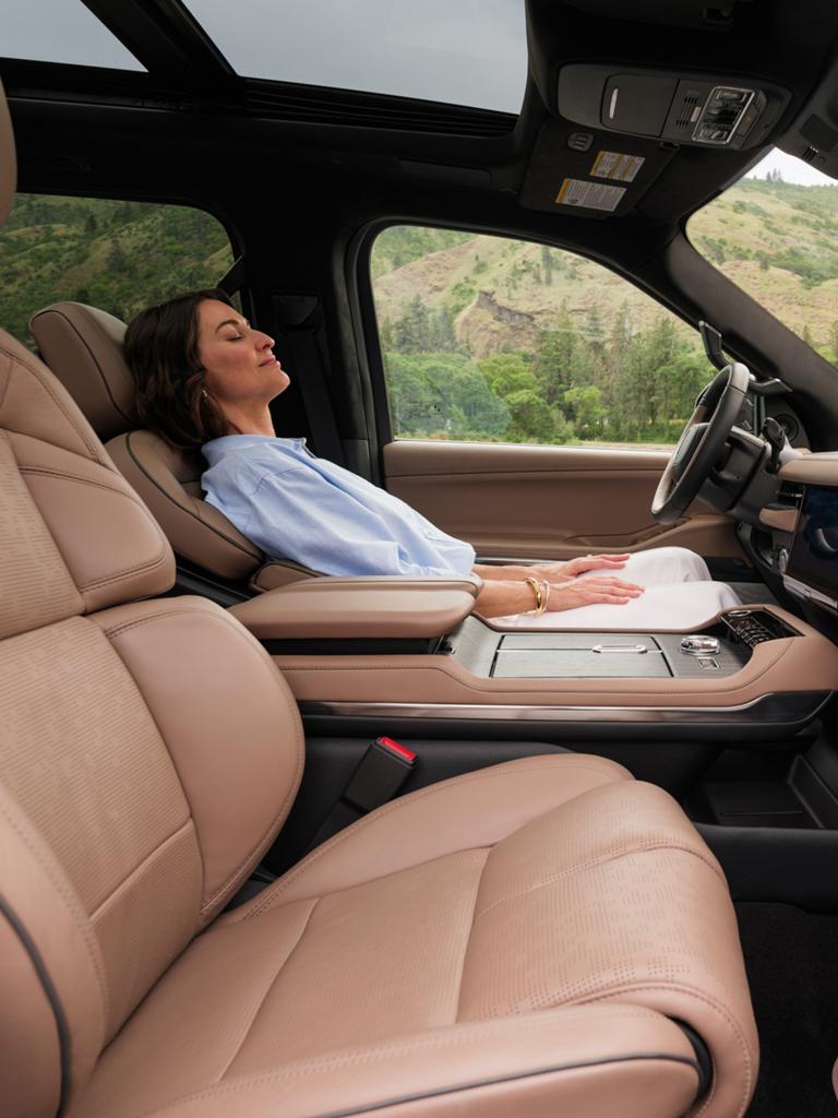 A woman reclines in a 2026 Lincoln Black Label Navigator® while the Elements Rejuvenate theme is playing on-screen