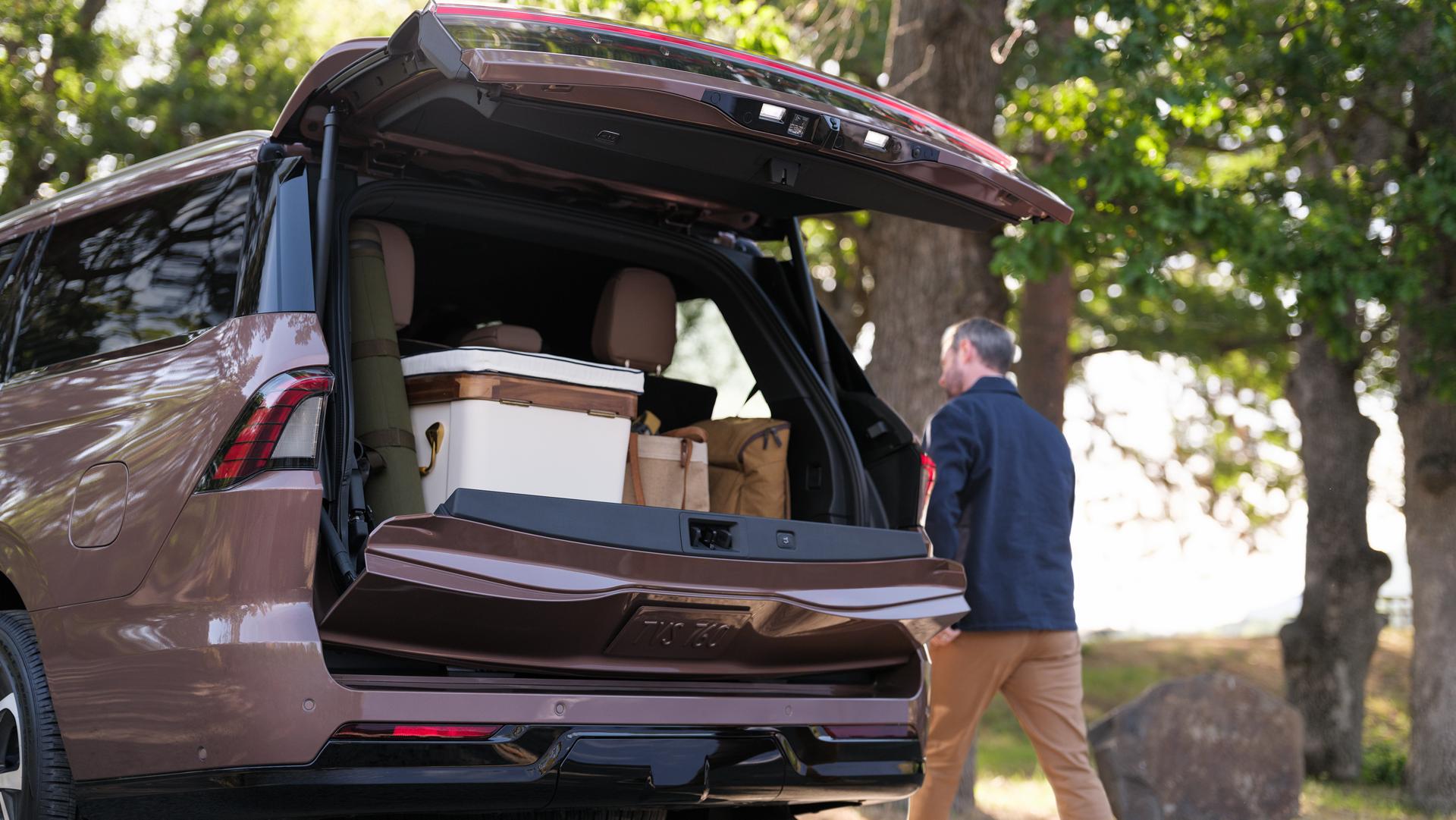 A man is walking next to the 2026 Lincoln Navigator where the trunk space is shown