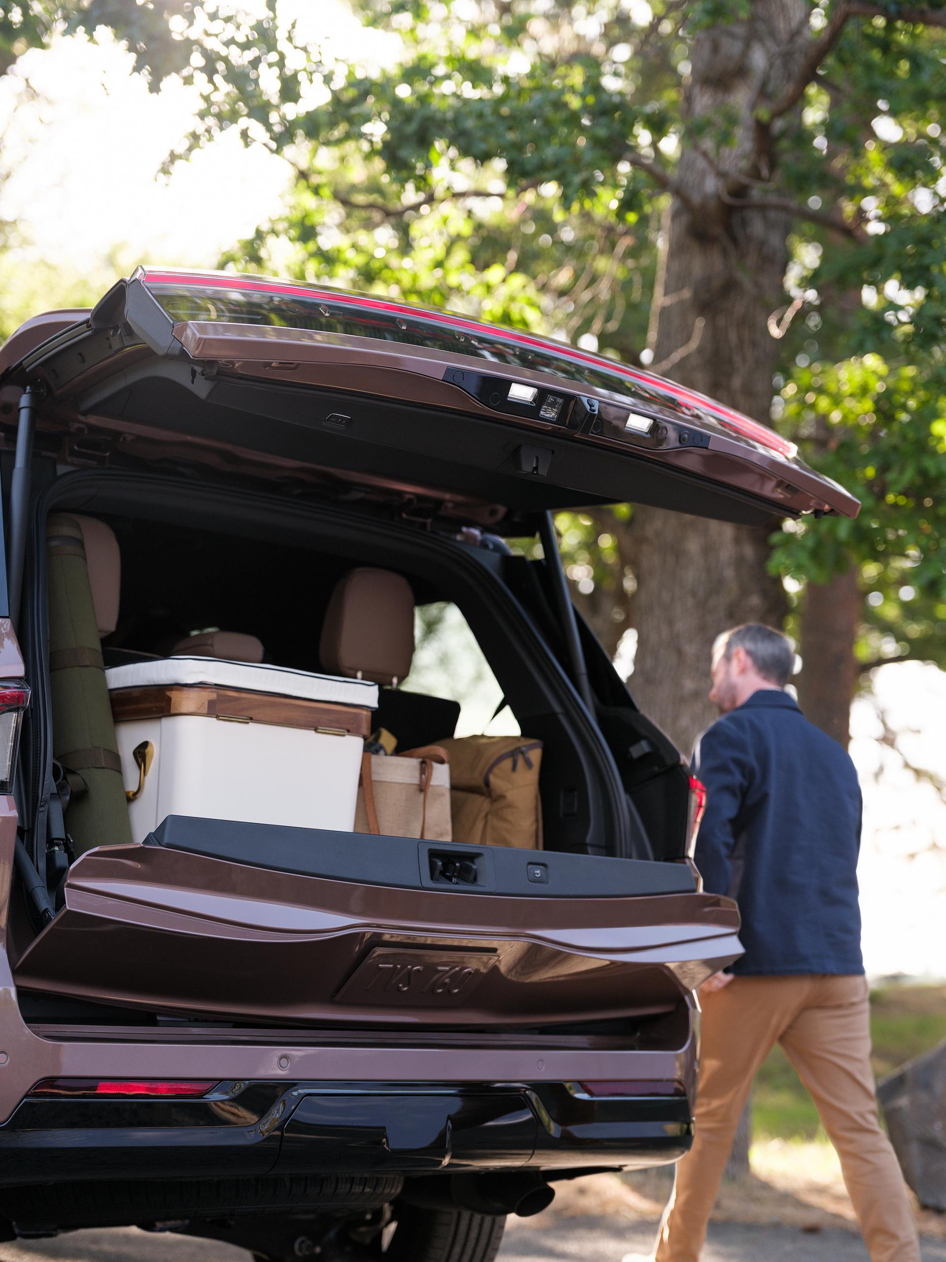 A man is walking next to the 2026 Lincoln Navigator where the trunk space is shown