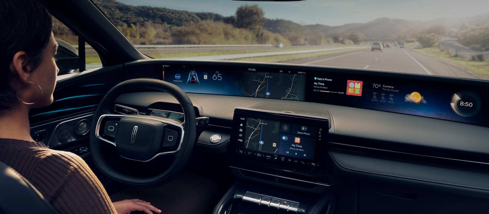A woman is shown driving Lincoln Nautilus SUV hands-free using Lincoln BlueCruise on a highway.