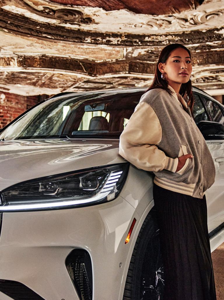 A woman leaning on a white 2025 Lincoln Aviator