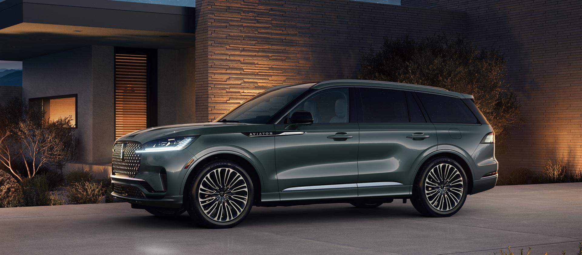 A 2027 Lincoln Aviator® Black Label® is parked next to a modern home at night