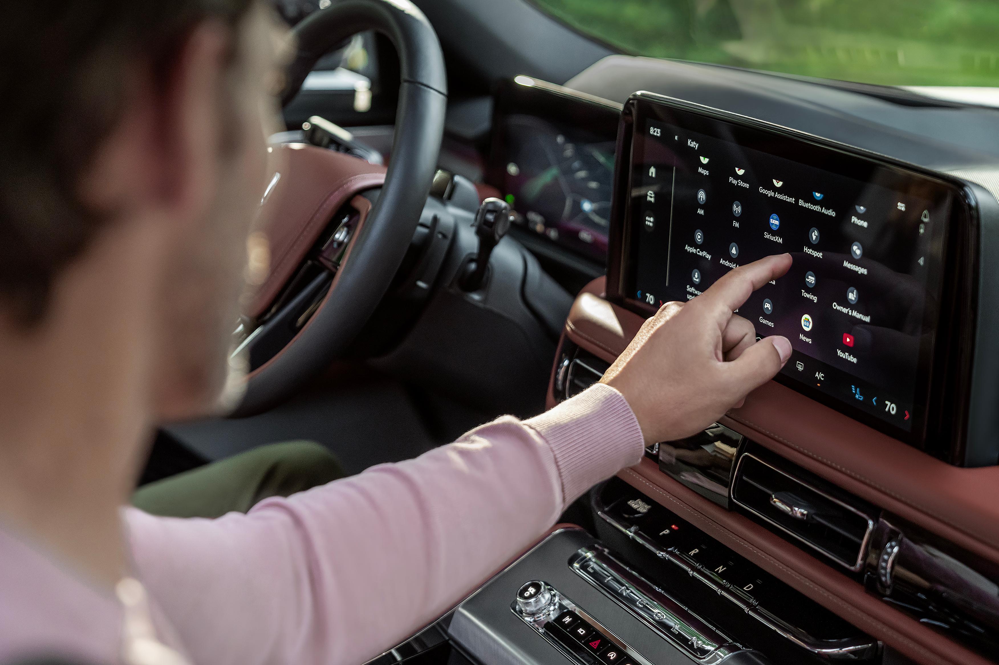 The driver of a 2026 Lincoln Aviator interacting with a touchscreen