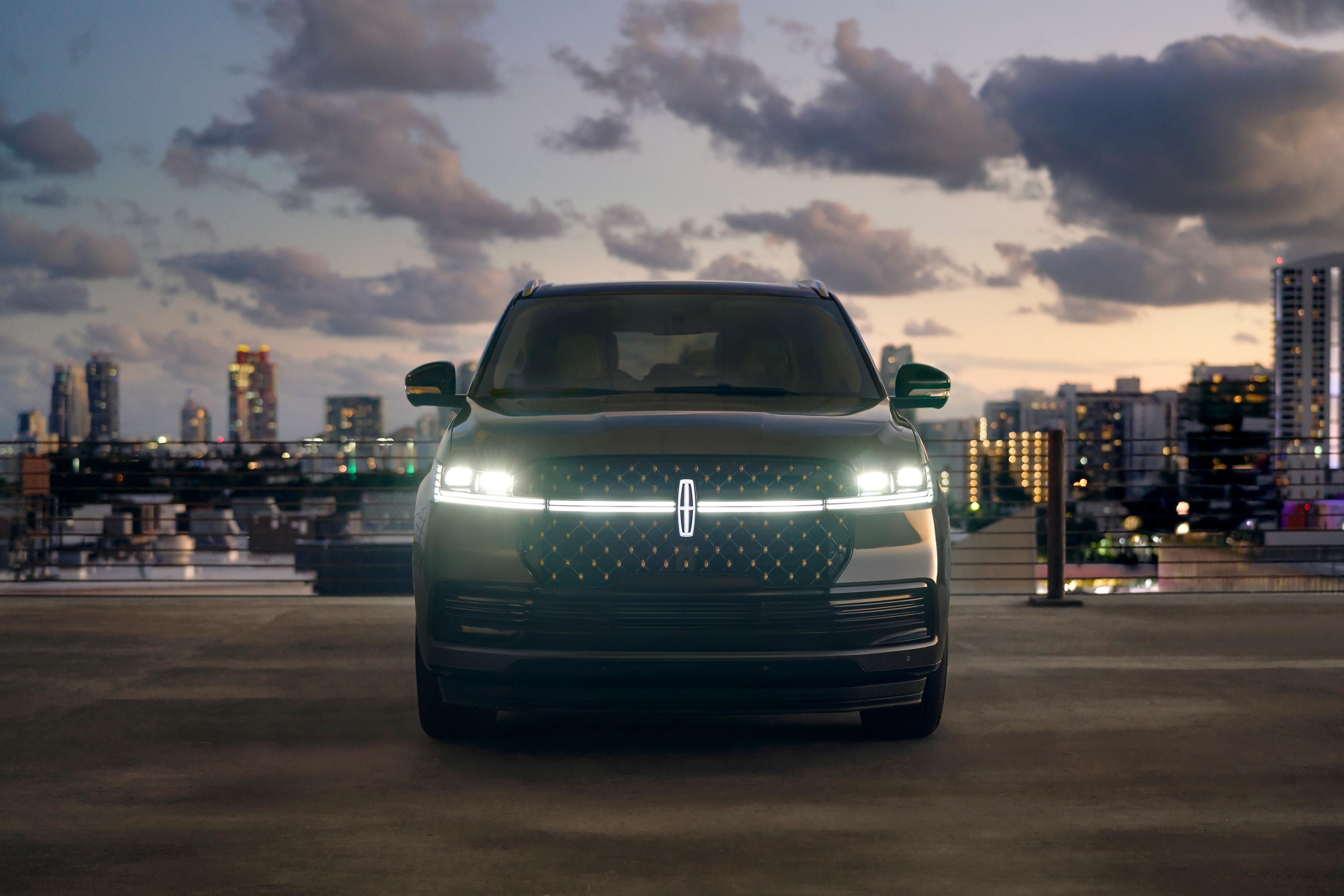 2026 Lincoln Black Label Navigator parked with a view of the city skyline at night in the background.