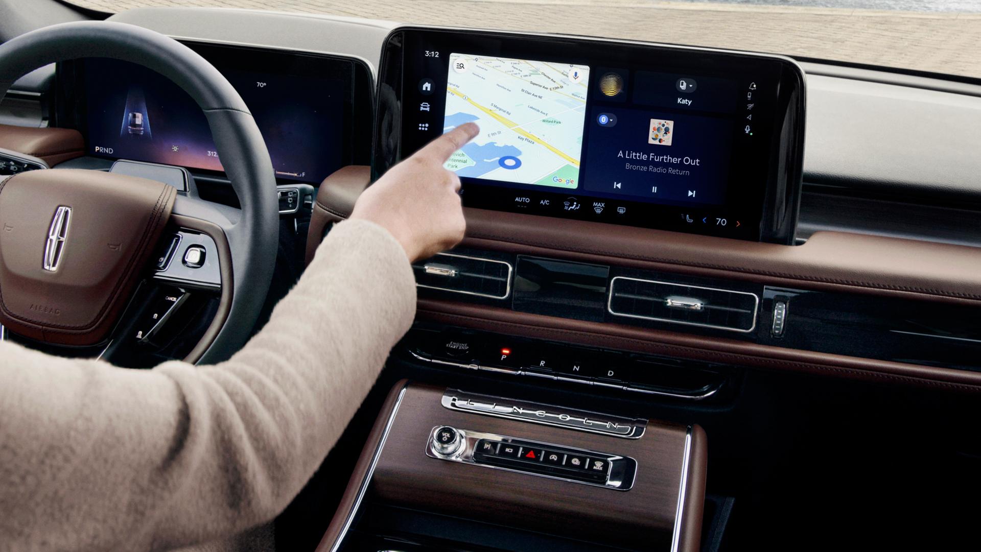 The front passenger touches the centre display inside a 2027 Lincoln Aviator