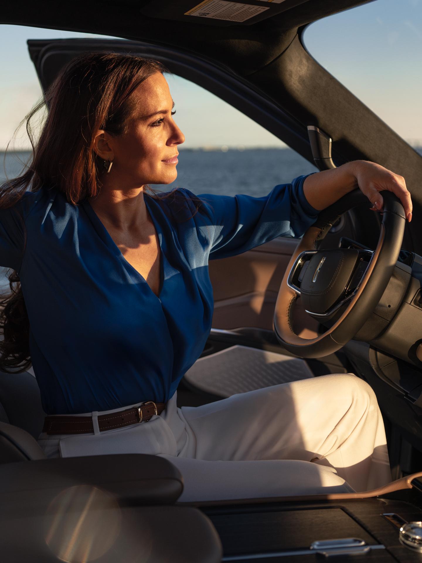 A woman sitting in a Lincoln vehicle.