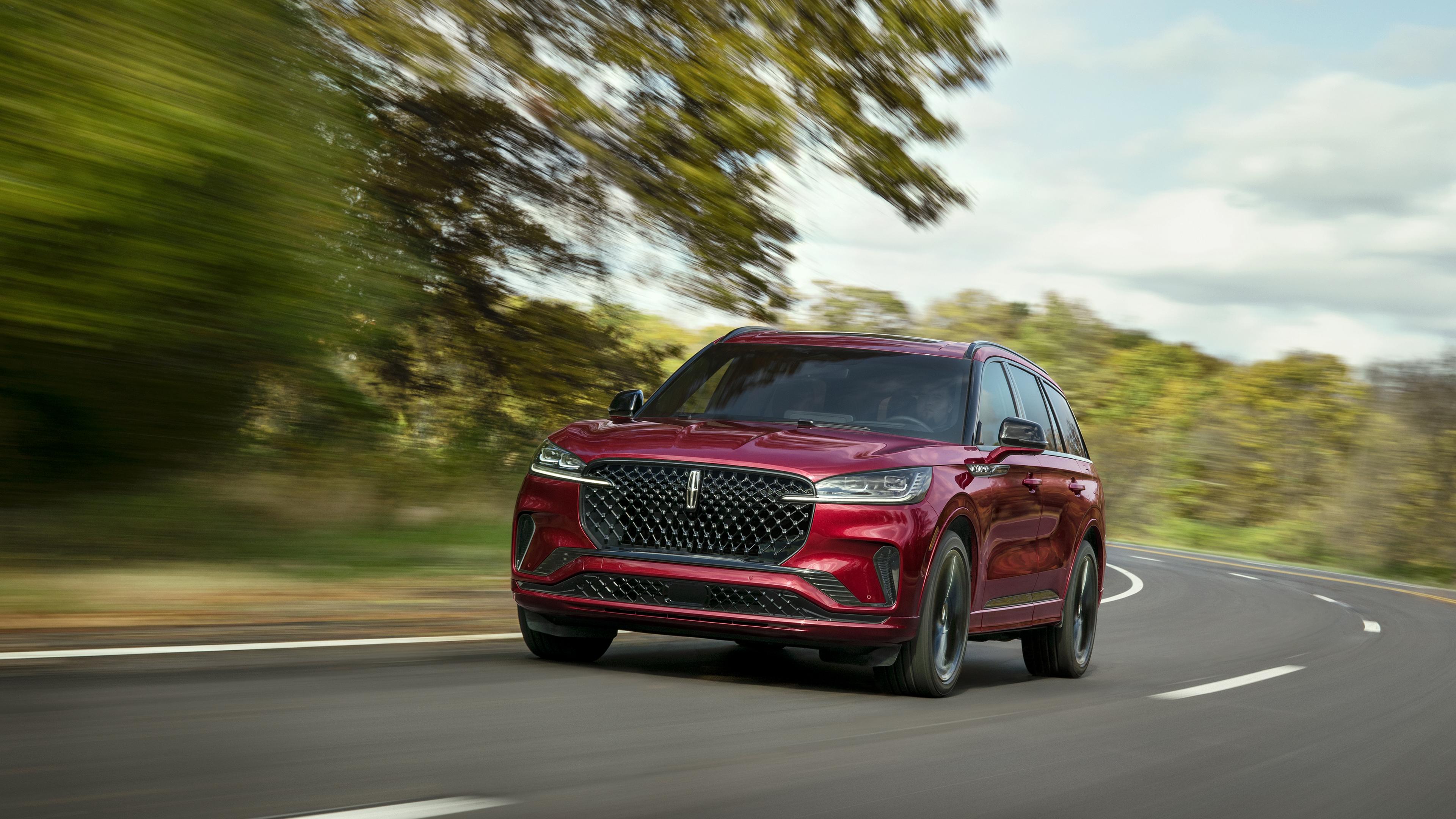 A 2027 Lincoln Aviator is being driven on a country road