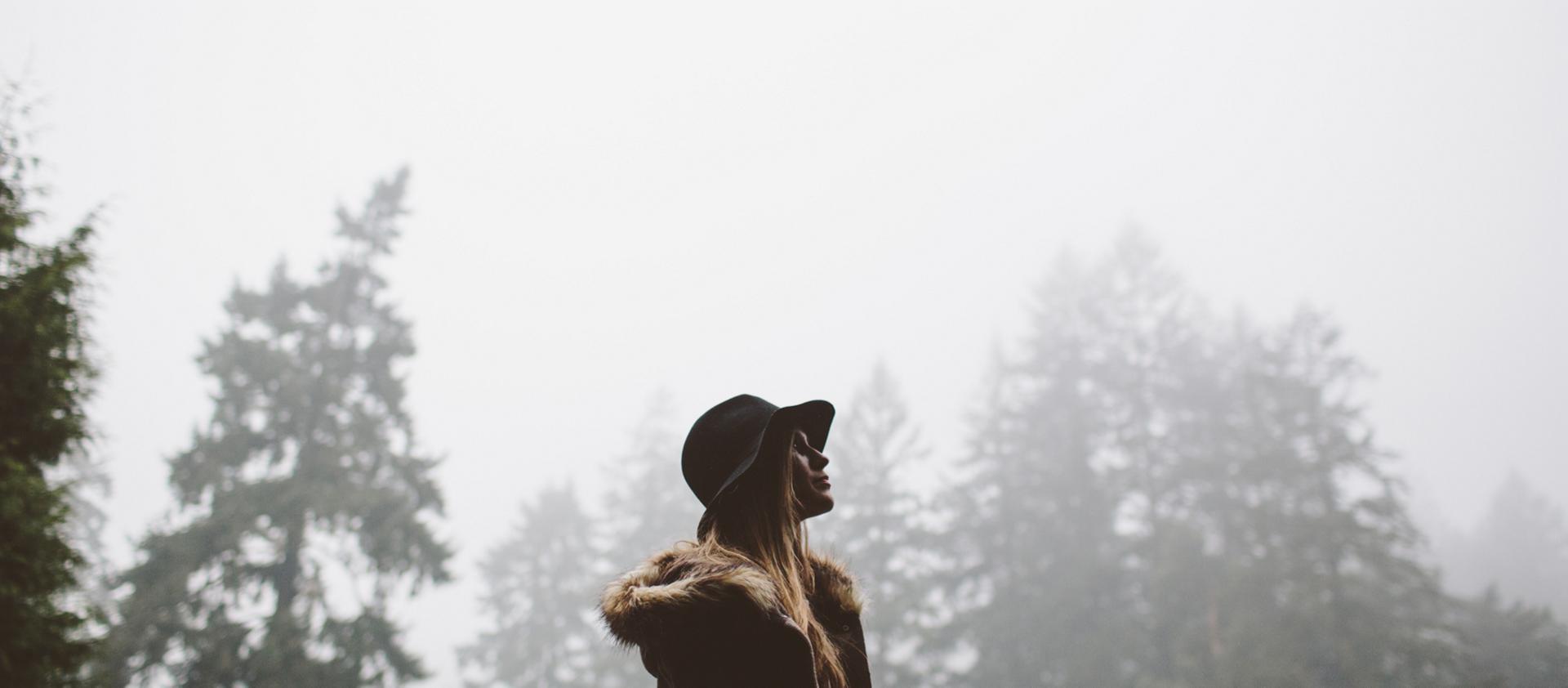 A woman walks through the forest following the conclusion of a rain storm